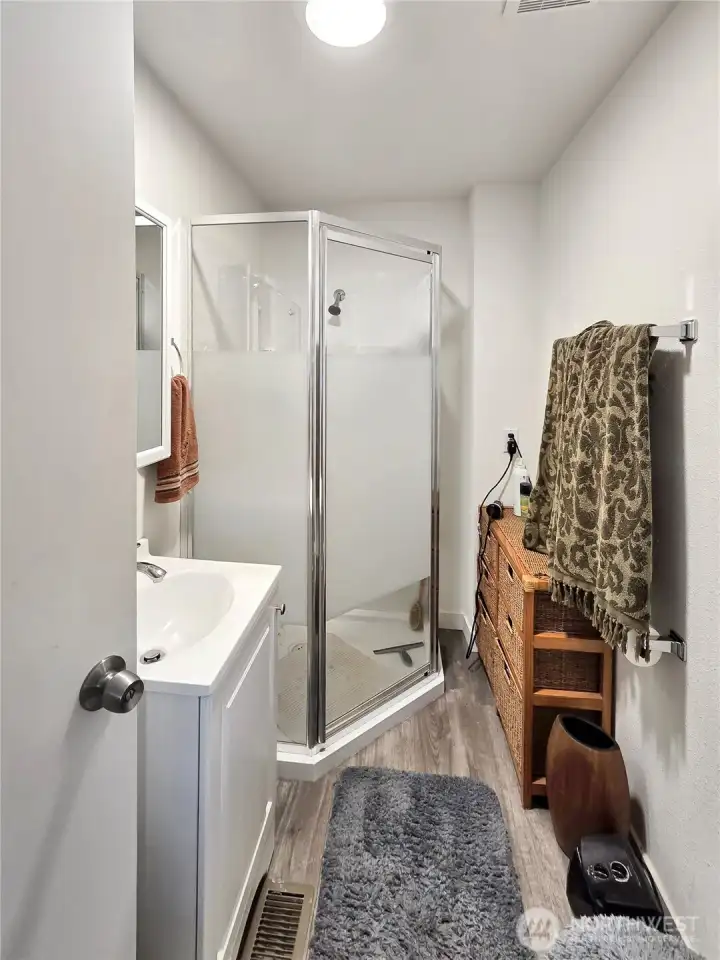 Updated primary bath featuring a corner shower and clean, modern finishes.