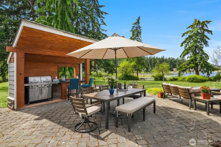 Spend warm summer days cooking in the covered outdoor kitchen, surrounded by the charm of the spacious cobblestone courtyard and serene lagoon views. Spend warm summer days cooking in the covered outdoor kitchen, surrounded by the charm of the spacious cobblestone courtyard and serene lagoon views.