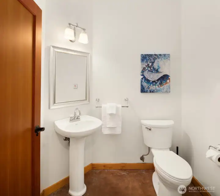 After kayaking, gardening, or spending the day on the beach, the powder room just off the mudroom offers a convenient place to clean up before entering the main living areas. After kayaking, gardening, or spending the day on the beach, the powder room just off the mudroom offers a convenient place to clean up before entering the main living areas.