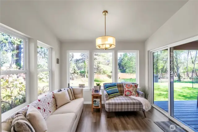 Nice and bright seating area with plenty of windows and sliding glass door to covered deck.