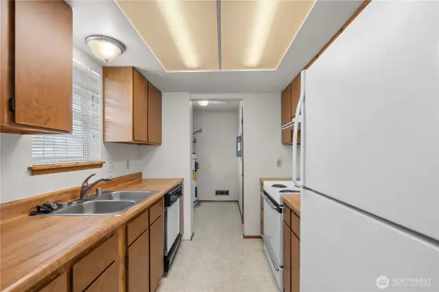 The kitchen open to the utility/laundry room with water heater and hookups for washer and dryer.