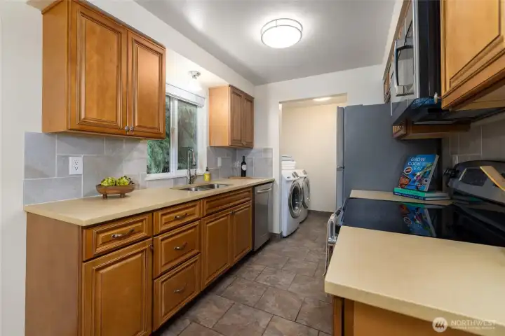 The kitchen has stainless steel appliances, tile backsplash and the laundry room is conveniently located with extra storage.