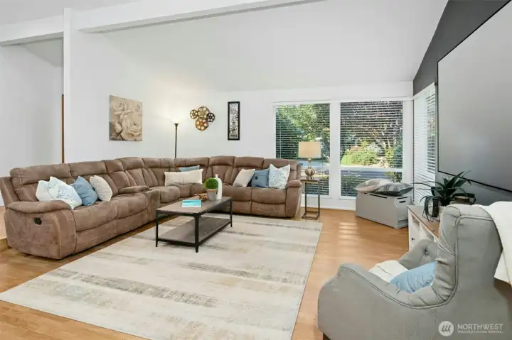 Bright and welcoming living room with vaulted ceilings and peaceful garden views.