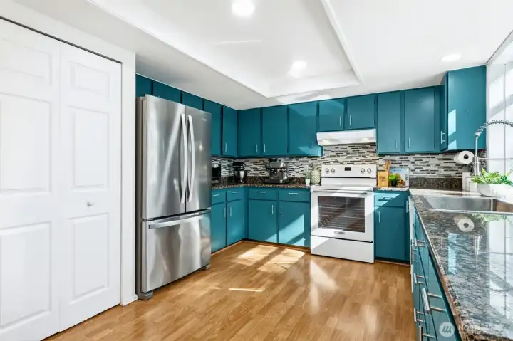 Updated stainless and white appliances complement the modern kitchen design.