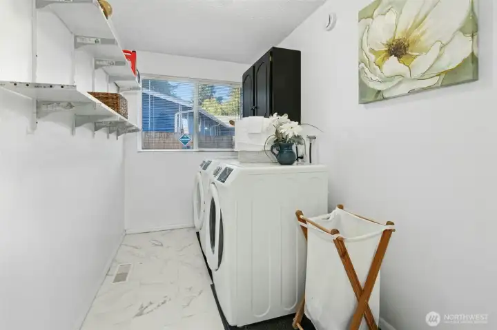 Spacious laundry with storage and natural light.