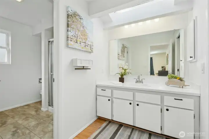 Bright ensuite bath with skylight and walk-in shower.
