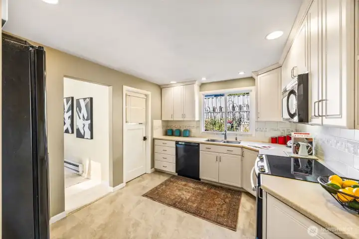 Kitchen was remodeled during ownership.  There is so much storage and counter space in this light and bright room. Closed door opens to utility room.
