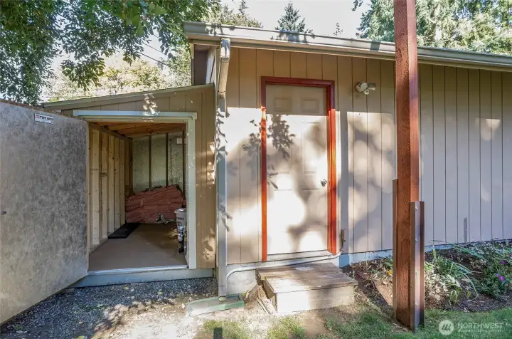 Side door to the detached garage with extra covered storage—ideal for all your needs!