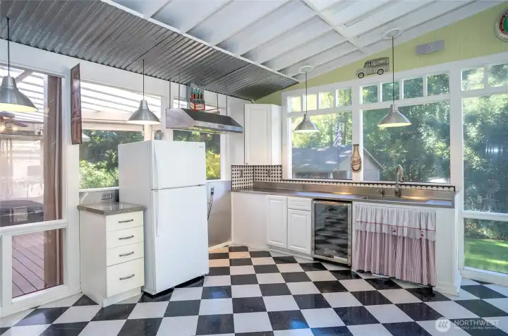 Enjoy this close-up of the kitchenette, perfectly positioned next to the expansive deck featuring a hot tub for year-round relaxation.