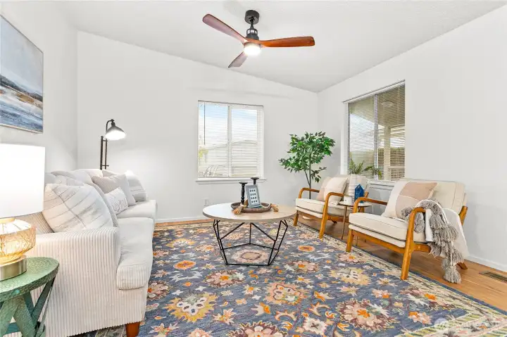Vaulted living room w/ceiling fan & lots of natural light