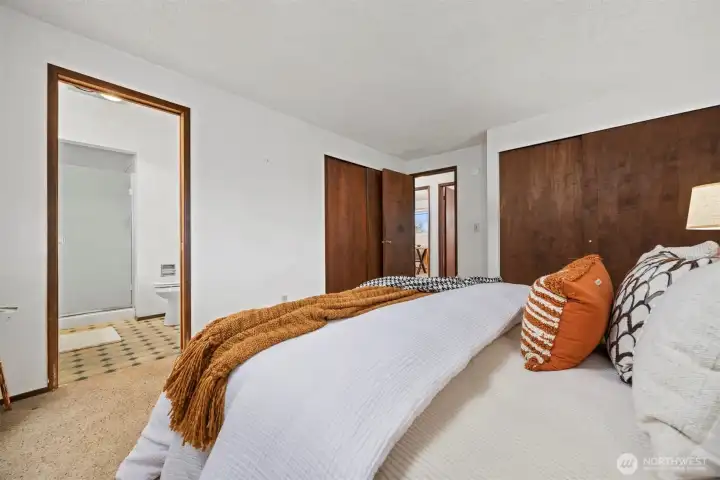 Looking across the primary suite with the 3/4 bath and two large closets.