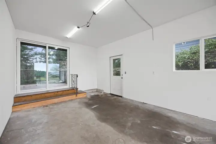 The attached garage has a glass sliding door and can be an extension of covered outdoor living space if entertaining as it connects to the spacious back deck.