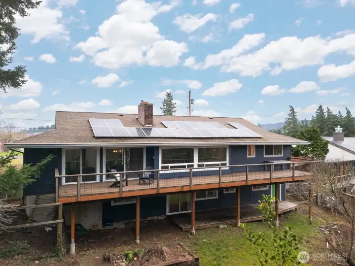 Looking at the rear elevation of the home and decks with the solar panels.