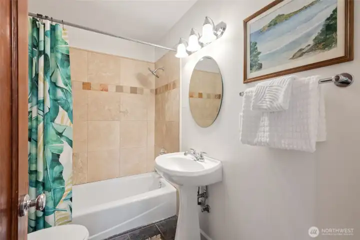 Main full bath with ceramic tile surround and slate floors. There is a good sized linen closet on the opposite wall.