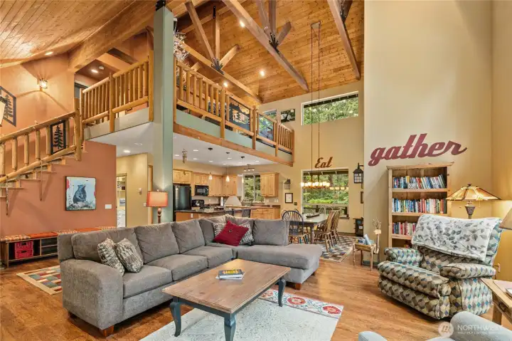 Light-filled living space with soaring ceilings, wood beams, and a cozy propane freestanding stove—ideal for relaxing after a day at the lake or on the trails.