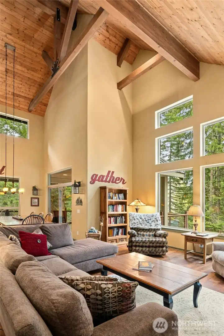 Bright and airy living space with expansive windows, warm wood tones, and a seamless connection to the surrounding natural beauty—perfect for everyday living and relaxed entertaining.