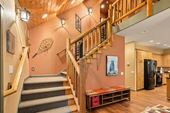 Striking stairway with handcrafted log railing leads to a versatile loft, office/den, and second bath—blending rustic character with flexible living space.
