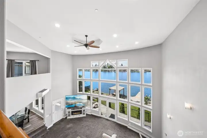 Expansive floor-to-ceiling windows span the family room, kitchen, and dining areas, filling the home with natural light and showcasing beautiful views while creating a bright, open-concept living experience.