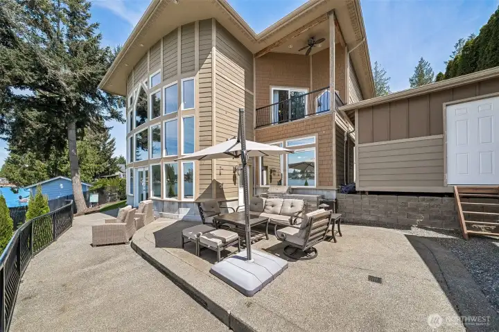 Large Elevated deck with sleek metal railing captures sweeping views of the water, private boat dock, and expansive yard, creating an exceptional setting for relaxing or entertaining.