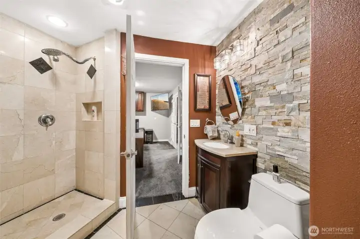 Just off the Jr. Suite is a well-appointed full bathroom features a decorative tile accent wall, a full-size tile surround shower, and a relaxing jetted tub.