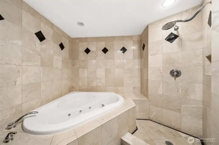 Main floor junior primary suite boast an oversized jetted tub and full tile wall surround.