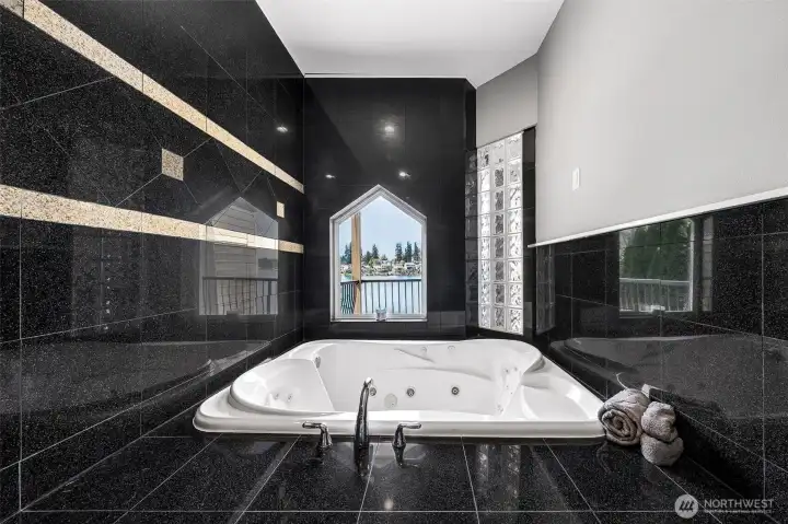Impressive oversized primary jetted tub with full tile surround.