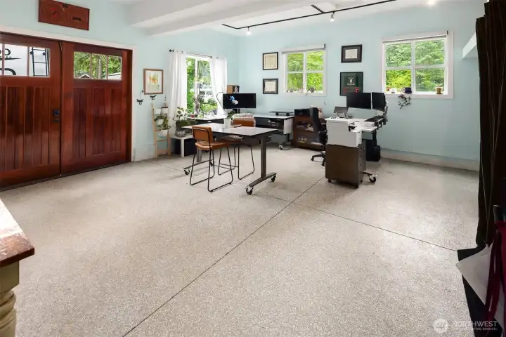 Climate-controlled converted garage living space with overhead storage and second dryer hookup.