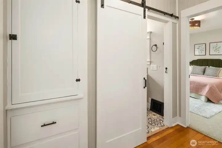 Original built in cabinets for additional storage and charming new barn door mixing old and new- creating a cozy modern feel