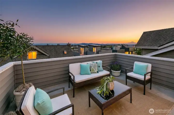 A private rooftop living room for evening conversation, city views and open sky.