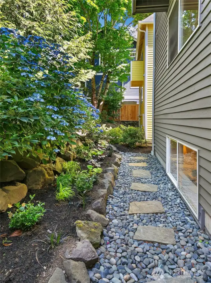 Landscaped side path leads through the garden to the private entry.