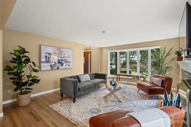 A view from the dining room towards the beautiful living room bay window that brings the outdoors right in to the home.