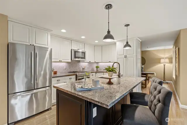 The kitchen has been updated with granite on the island and quartz countertops around the cooktop. The cabinetry was also updated, as well as all of the appliances. Hardwood flooring continues into the kitchen as well.