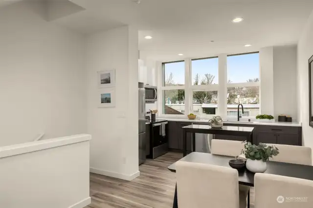 Open concept kitchen, complete with stainless steel appliance and windows that fill the space with natural light.