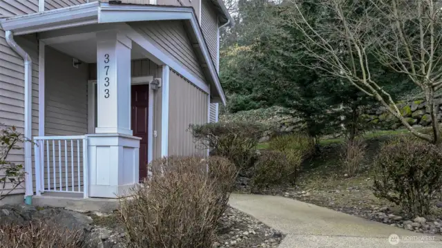 A vibrant red front door greets you with personality and warmth—inviting you into a peaceful retreat.