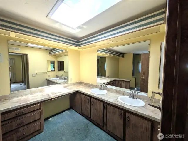Huge bathroom off of the primary bedroom. Double sinks and a shower. Garden tub was removed leaving a great space for additional cabinets or maybe a bench?