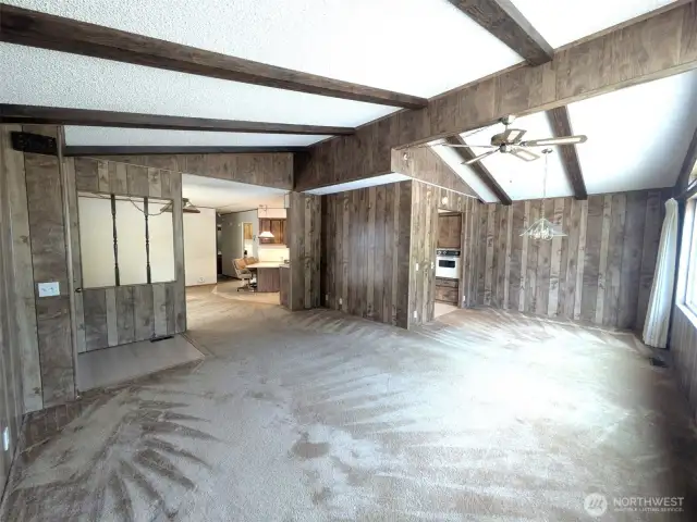 Large living and dining area with big picture windows letting in natural light. Vaulted ceilings.