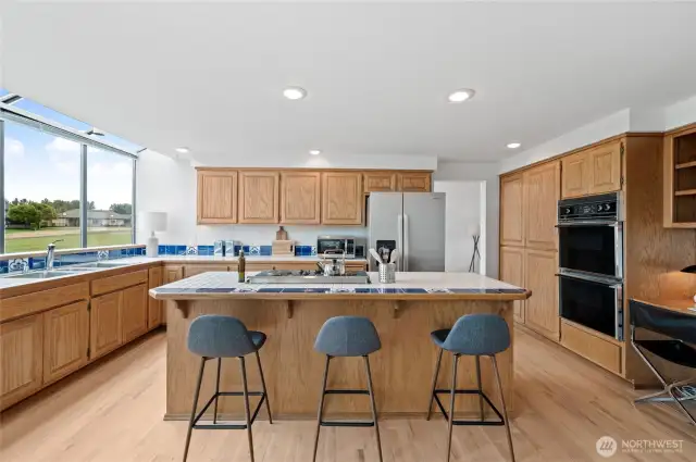 A spacious and elegant Kitchen featuring stainless steel appliances, dual ovens, and custom cabinetry, complete with a breakfast island perfect for quiet morning conversations.