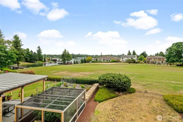 Private patio view of 4th Fairway and Lake Tapps; clouds are hiding the full view of Mount Rainier.