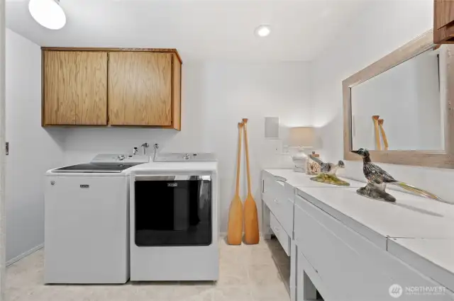 Before entering the garage, there is a large utility room with generous counter space and a sink...plus another quarter bath  to simplify your life while working at the shop bench in the garage, or gardening outside in the yard.