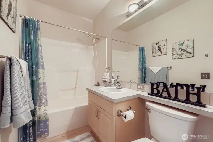 Full sized bathroom with full wall mirror. Well maintained