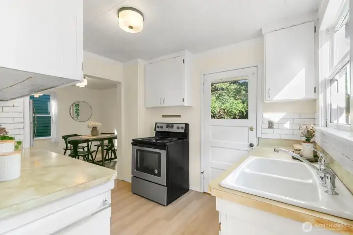 From the kitchen entry, you can see the additional eat-in space. There is so much potential here to enlarge the kitchen. Note the entry to the back porch/backyard.