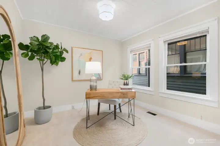 The main floor bedroom is tucked away from the living spaces. Currently staged as an office, but easily accommodates a queen bed.