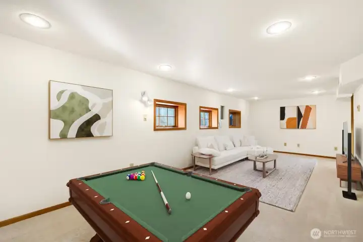 Enter the lower level to the rec room. This room is sizable and allows for a game room and tv/entertainment space. This room is virtually staged.