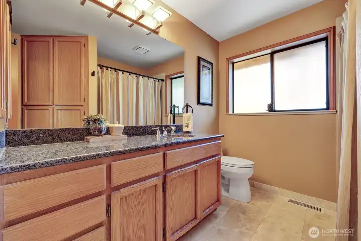 Guest bathroom features granite countertops and updated lighting in all baths