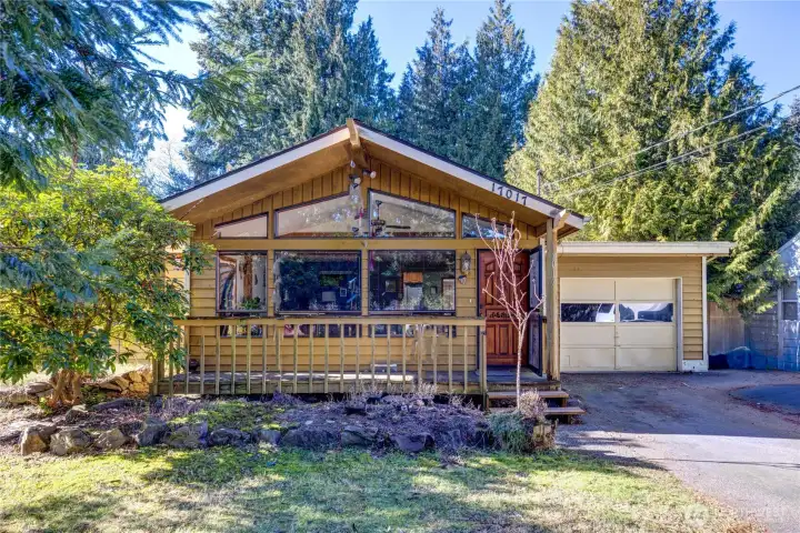 Inviting front porch great place to enjoy slow mornings or evenings under the evergreens.