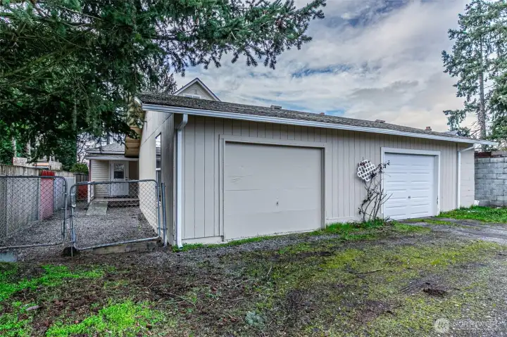 Alley view of oversized garage & gate access to yard on the left.  Garage has grandfathered 1/2 bath.
