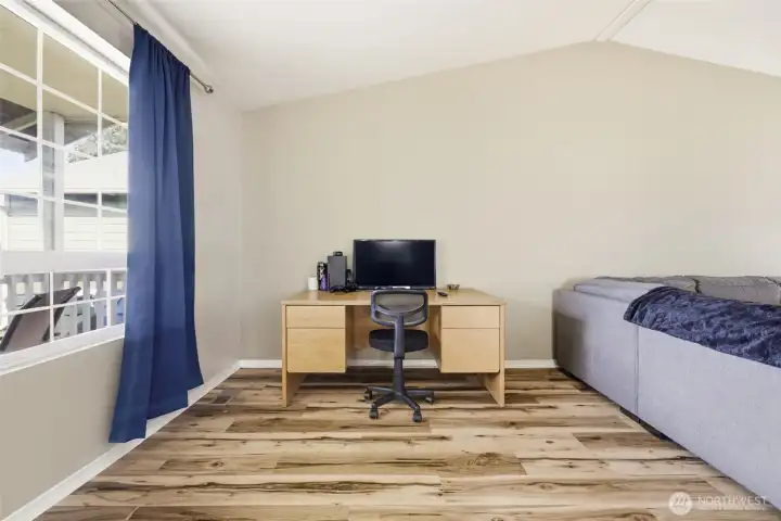 Spacious living room with vaulted ceilings and plenty of natural light, plus a versatile area perfect for an office desk, reading nook, or hobby space.