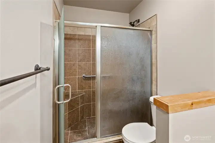 Inviting bath highlighted by a custom walk-in tile shower.