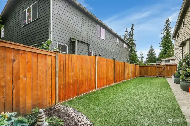Fully-fenced backyard with turf.