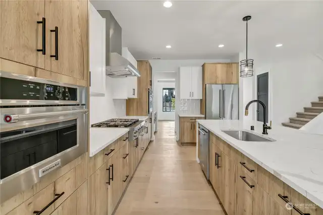 Light & bright kitchen/great room with natural wood floors, white with black accents